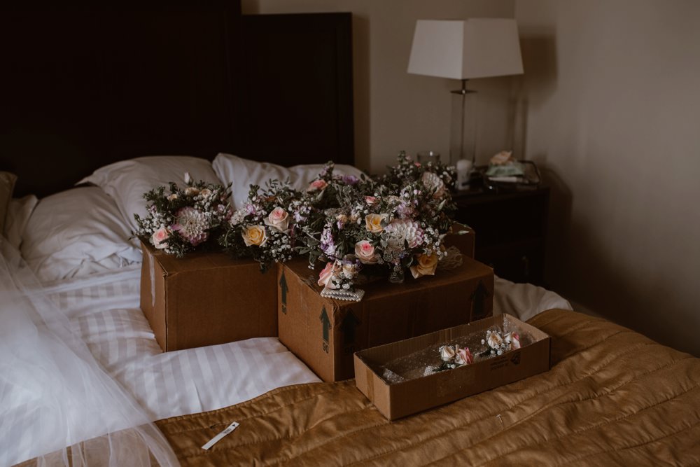 bouquets in boxes on the bed for bridal party.