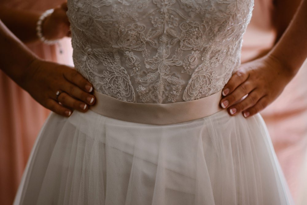 Detail of brides dress, with silk sash.