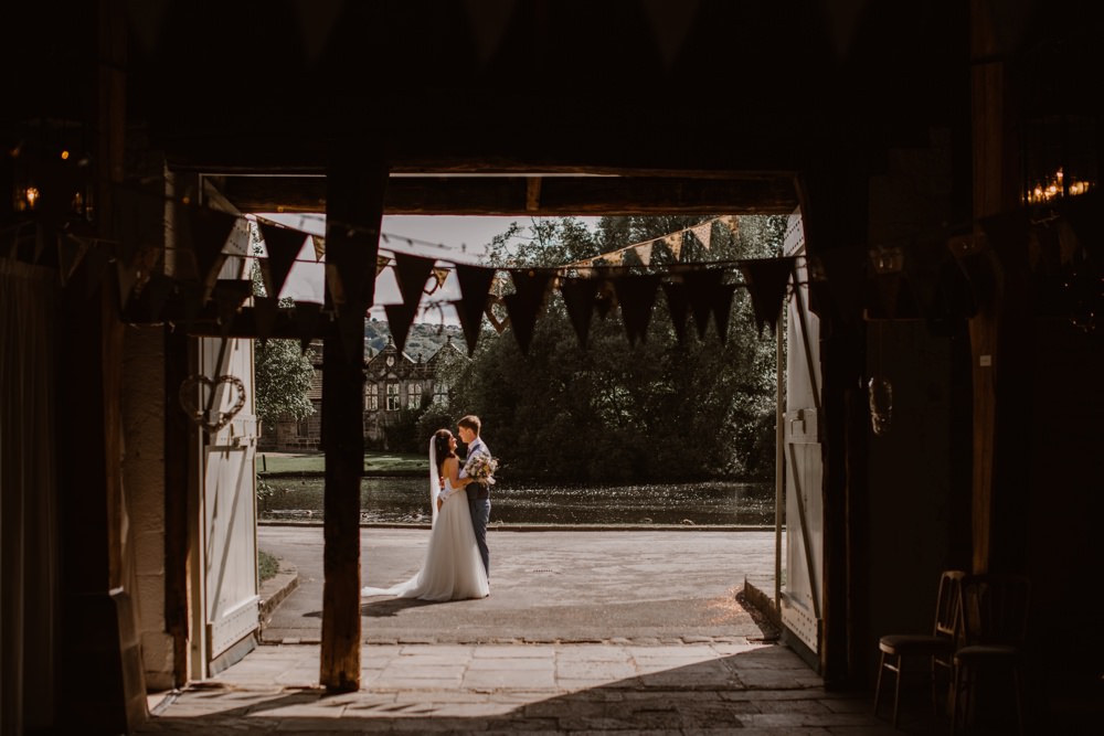 The rustic barn doorway frames an image of the couple outside