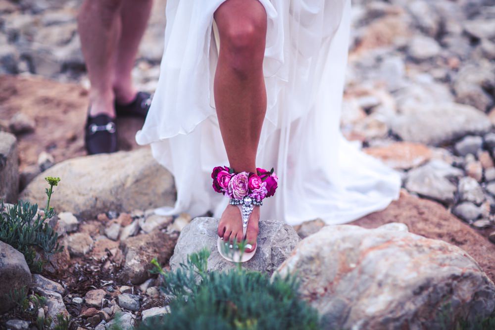 Detail of brides shoes a she walks over the rocks