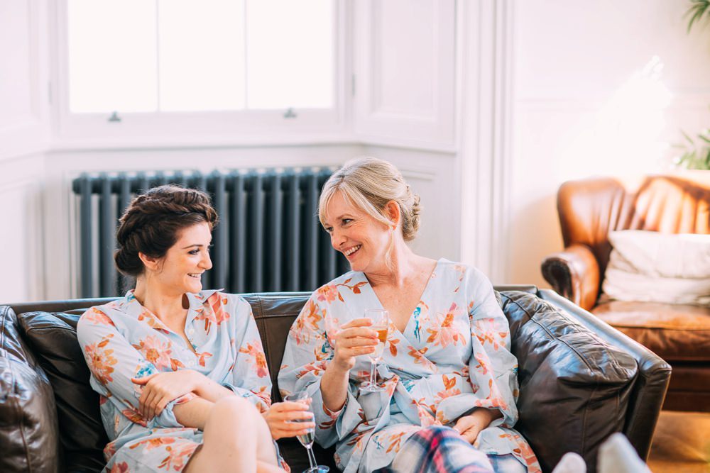 Bridesmaid in matching dressing gowns with champagne for breakfast