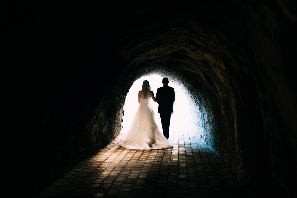 The Tunnels beach venue, bride and her father walking out into the light to the wedding