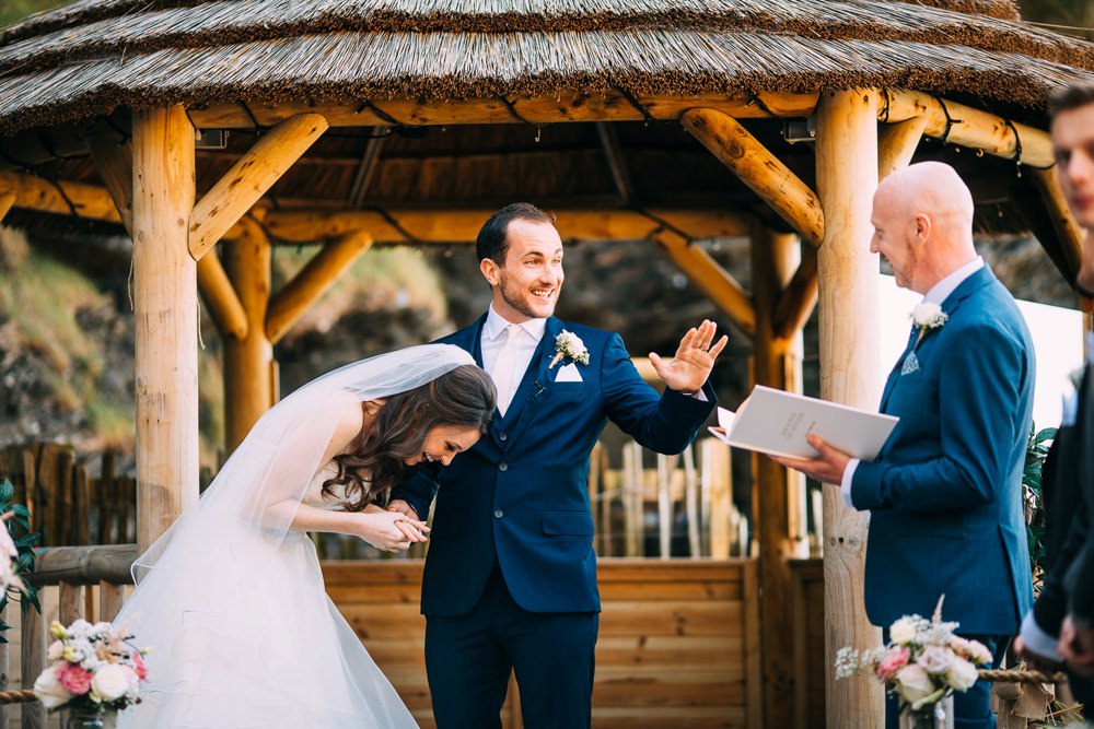 a humourous moment during the wedding as bride laughs at groom