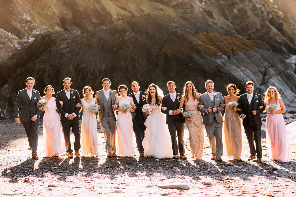 The bridal party laughing on the beach