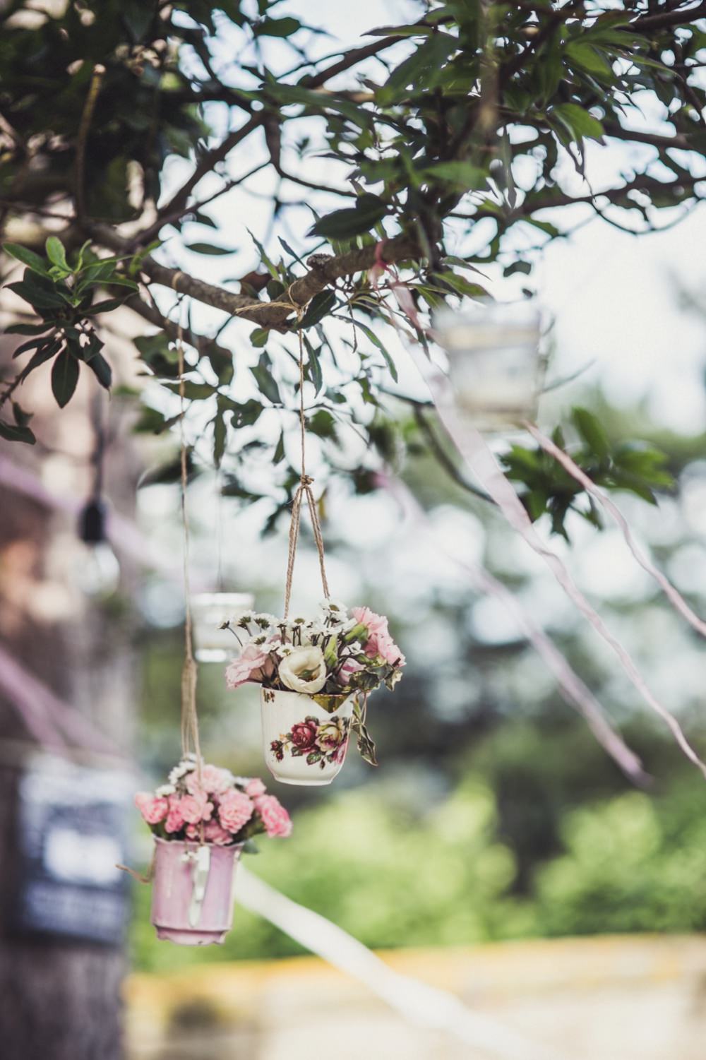 teacups with flowers hanging from trees